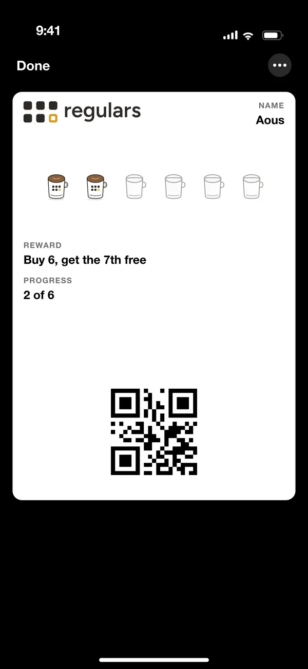 A Regulars loyalty card open in Apple Wallet on an iPhone: two of six coffee stamps collected, buy six get the seventh free, with the customer's QR code underneath.